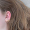 Twist earring with round stone and gold details